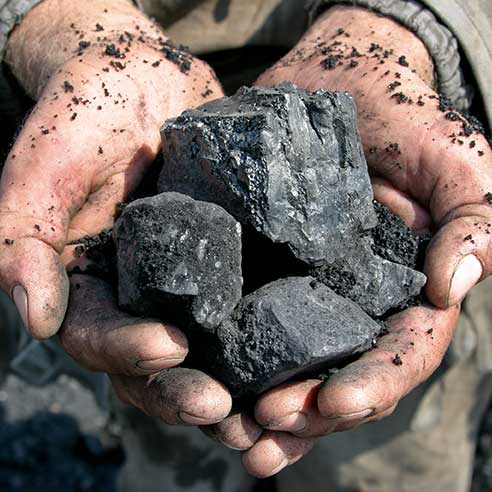A picture a person's hands holding coal.